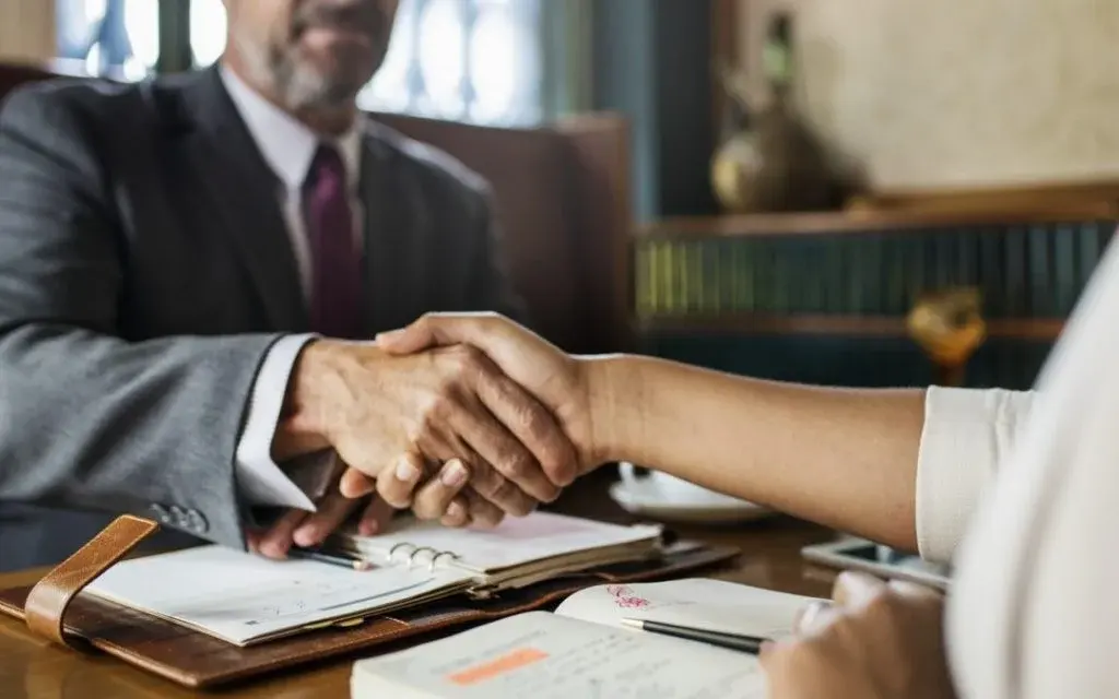 Personal injury attorney shaking hands with a client in a Las Vegas law office
