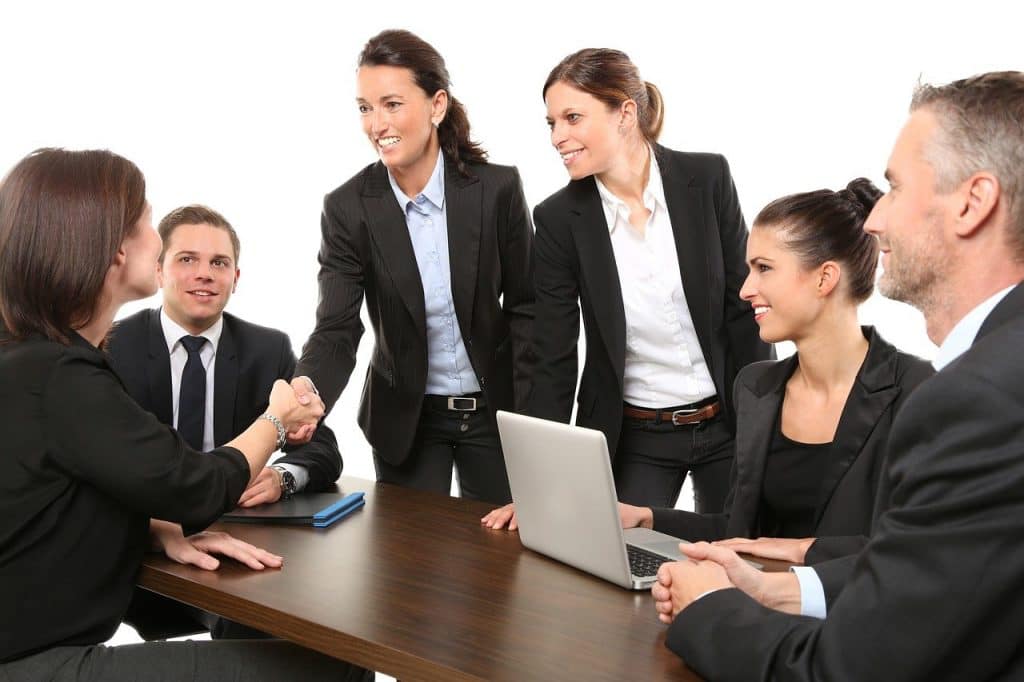 Attorneys shaking hands with a client across a meeting table
